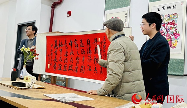 旅秘書法家向現(xiàn)場(chǎng)觀眾展示書法作品。人民網(wǎng)記者 宋亦然攝