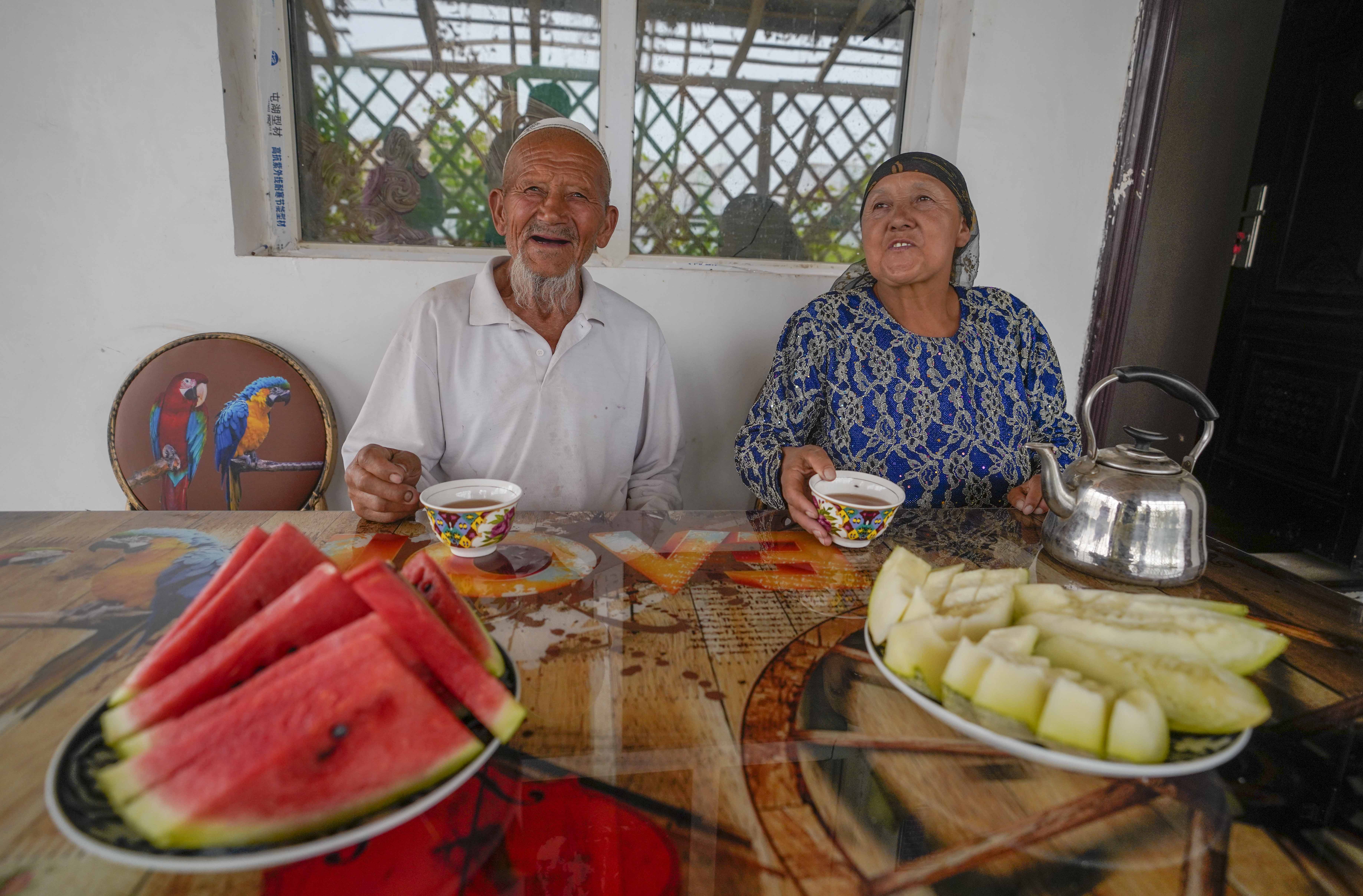 在新疆喀什地區(qū)伽師縣江巴孜鄉(xiāng)依帕克其村57號，80歲的維吾爾族老人伊米提·艾山（左）在自家庭院中（2020年6月8日攝）。
