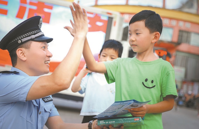 ▲7月10日，江西省吉安市公安局吉州分局組織民警深入轄區(qū)開展安全宣傳，民警向小朋友講解防溺水知識(shí)。朱文杰攝