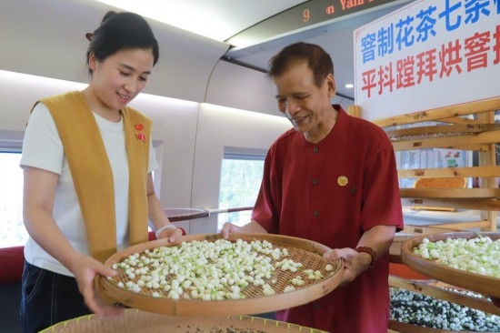 10月1日，福州市茉莉花茶窨制工藝代表性傳承人張子建與旅客在G1634次列車上制作茉莉花茶。新華社記者周義 攝