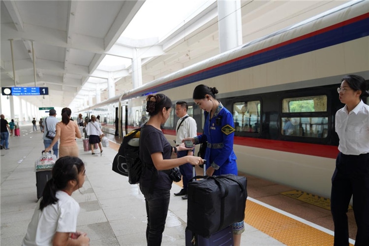 中老鐵路工作人員在站臺(tái)指引旅客進(jìn)站乘車。老中鐵路有限公司供圖