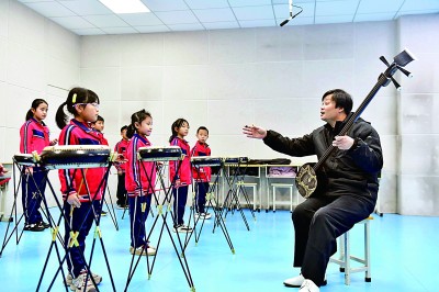 圖為12月30日，在惠民縣胡集鎮(zhèn)第一小學(xué)，老師指導(dǎo)學(xué)生學(xué)習(xí)西河大鼓。新華社記者 郭緒雷攝