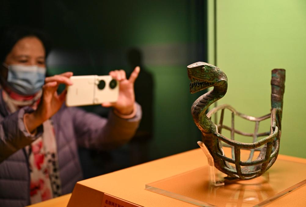 1月14日，觀眾在上海博物館蛇年迎春展拍攝展品蛇綱網(wǎng)狀銅器。新華社發(fā)（陳浩明攝）