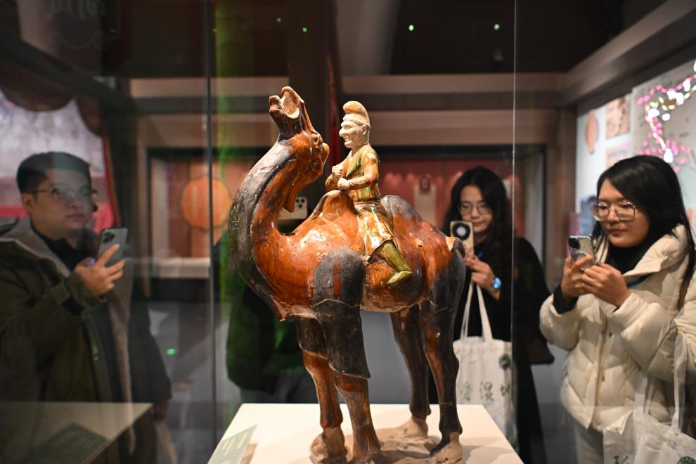 1月15日，觀眾在拍攝“長安三萬里——陜西唐代文物精華展”展出的三彩胡人騎駝俑。（新華社記者 孫凡越 攝）