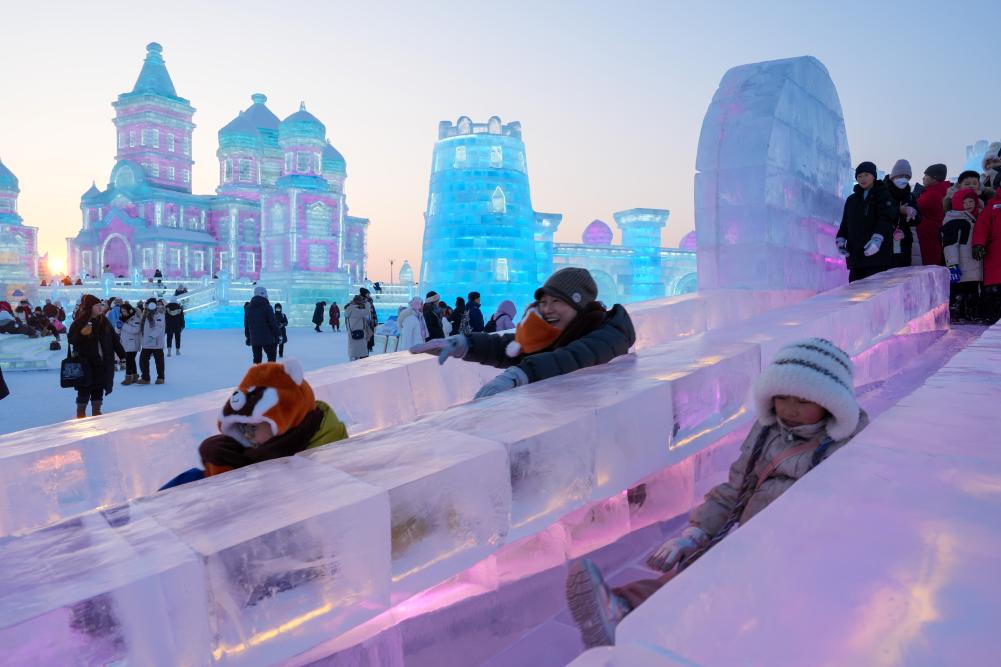 游客在哈爾濱冰雪大世界園區(qū)內(nèi)體驗(yàn)冰滑梯。新華社發(fā)