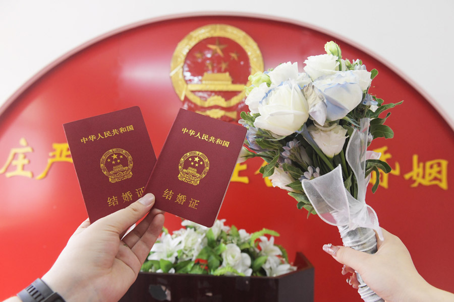 2024年8月10日，一對新人在河北石家莊新樂市民政局婚姻登記處領(lǐng)取結(jié)婚證后拍照留念。新華社發(fā)（賈敏杰攝）