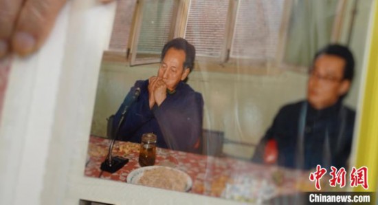 2月7日，劉潤林展示1986年黃旭華(左)在同樂會上吹口琴的老照片。中新社記者 鄒浩 攝