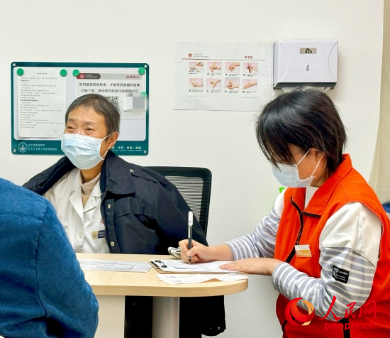 秦苑（中）接診患者。人民網(wǎng)記者 金慧慧攝