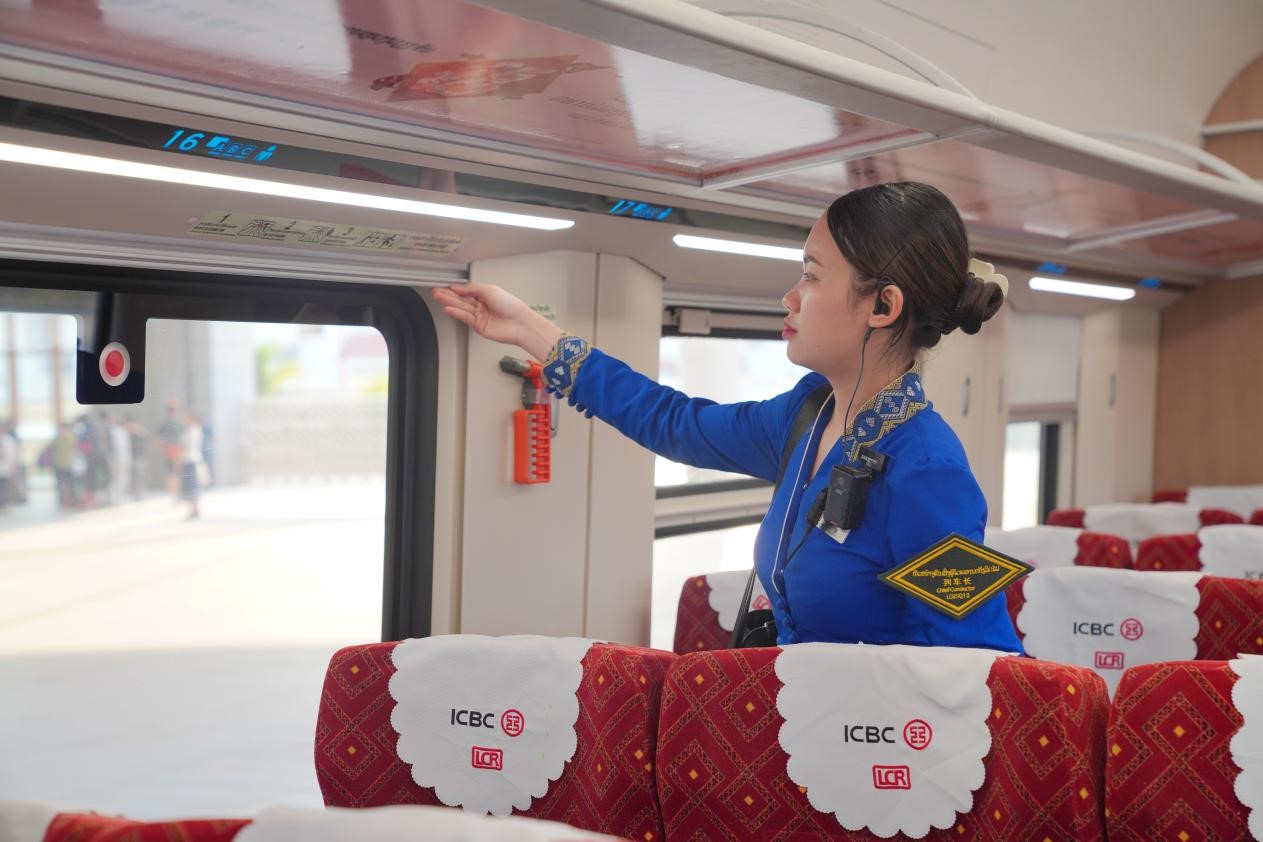 中老鐵路瀾滄號(hào)動(dòng)車組列車長(zhǎng)小麗正在進(jìn)行車廂檢查。老中鐵路有限公司供圖