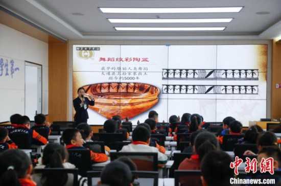 圖為學(xué)生在“國寶音樂會(huì)”社教課中了解舞蹈紋彩陶盆。中新社記者 馬銘言 攝