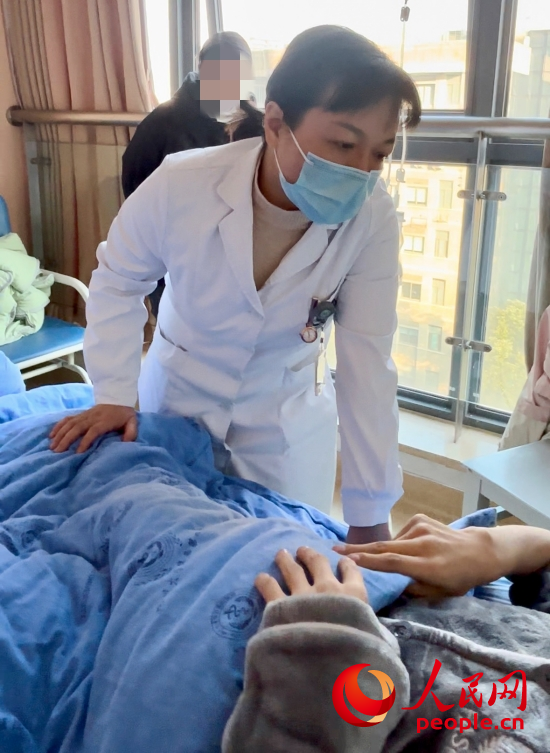 鄧茜查房時詢問患者情況。人民網(wǎng)記者 金慧慧攝