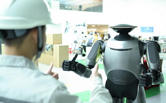 在廣汽研究院，人形機器人團隊的周仁義在演示GoMate機器人互動功能（新華社記者 鄧華 攝）