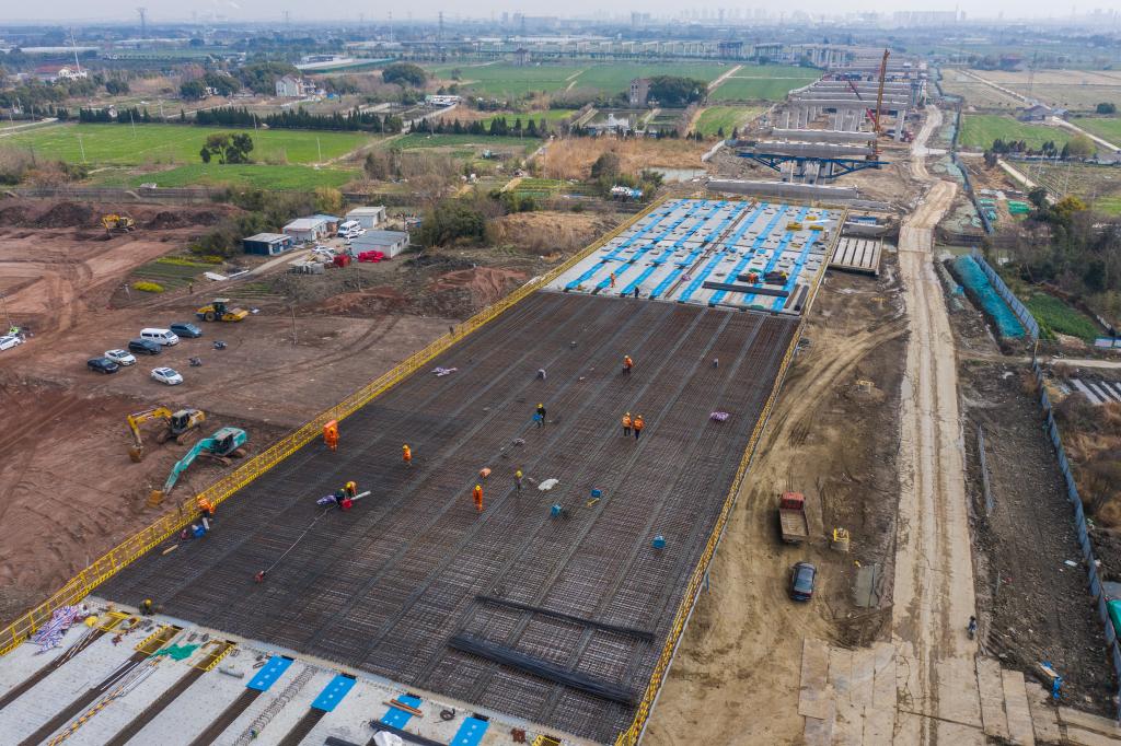 3月7日，在524國(guó)道秀洲王江涇至新塍公路工程TJ02標(biāo)段，作業(yè)人員正在進(jìn)行60米鋼混組合梁現(xiàn)澆橋面板鋼筋焊接及綁扎作業(yè)（無(wú)人機(jī)照片）。新華社記者 徐昱 攝
