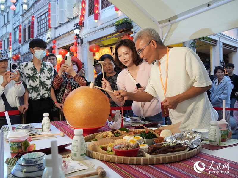 嘉賓品嘗海南傳統(tǒng)美食“煎堆”。人民網(wǎng)記者 張力洋攝