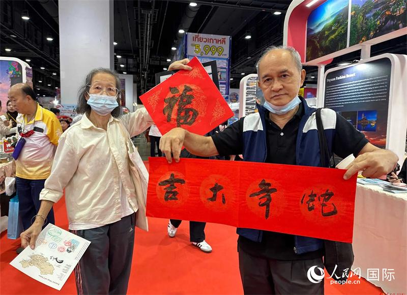 2025蛇年春節(jié)，泰國市民展示他們領(lǐng)到的華人手寫春聯(lián)。人民網(wǎng)記者 簡承淵攝