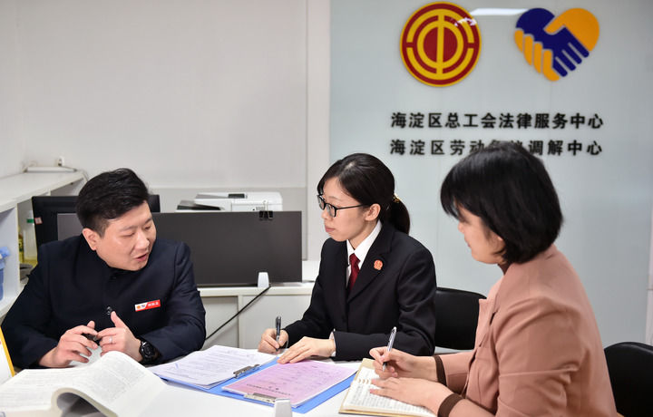 2025年3月6日，在北京市海淀區(qū)總工會勞動爭議調(diào)解中心，海淀區(qū)人民法院法官王琰（中）與該中心工作人員就糾紛化解情況進行溝通。新華社記者 趙婷婷 攝
