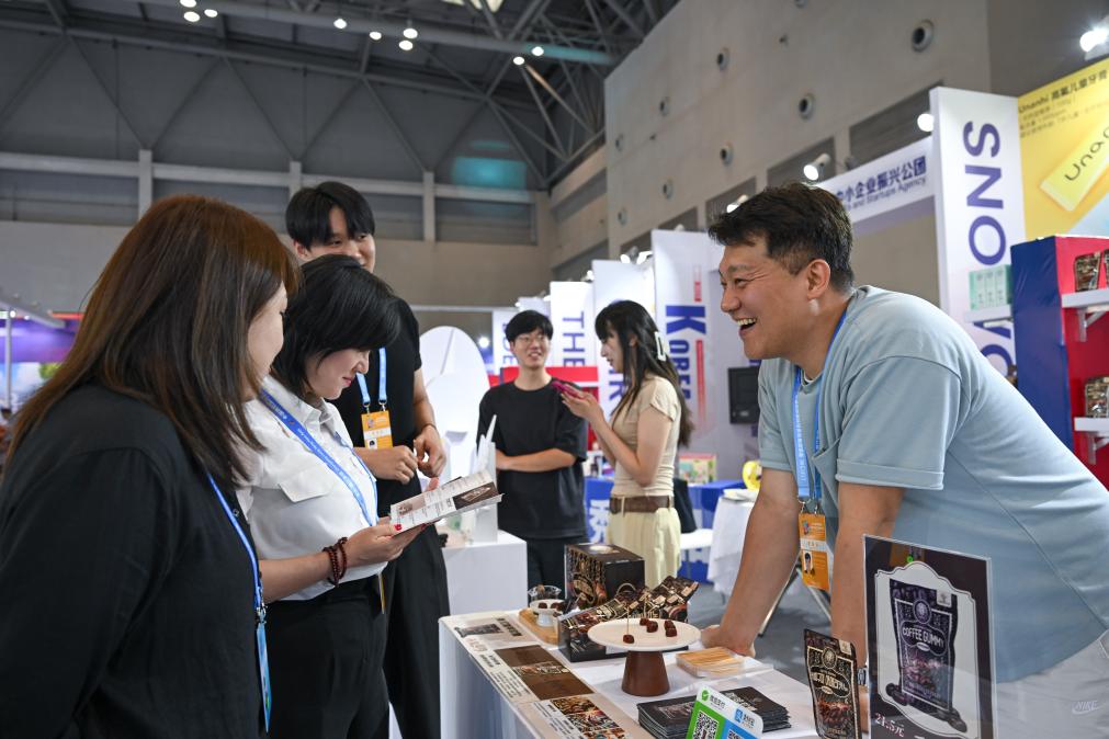 5月22日，韓國(guó)展商（右一）在西洽會(huì)現(xiàn)場(chǎng)向參觀者介紹產(chǎn)品。新華社記者 陳誠(chéng) 攝