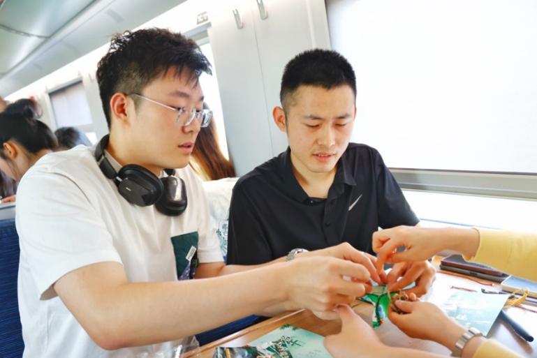 G232次旅客親手制作端午荷包和五彩繩。王磊攝