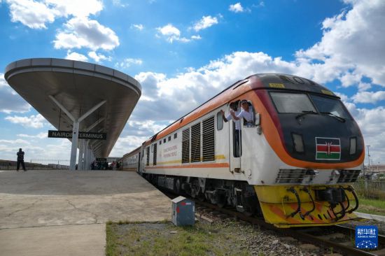5月31日，在蒙內(nèi)鐵路內(nèi)羅畢站，機車駕駛員蔣立平（右）和博爾在即將開往蒙巴薩的E2次列車上揮手致意。新華社記者 楊光 攝